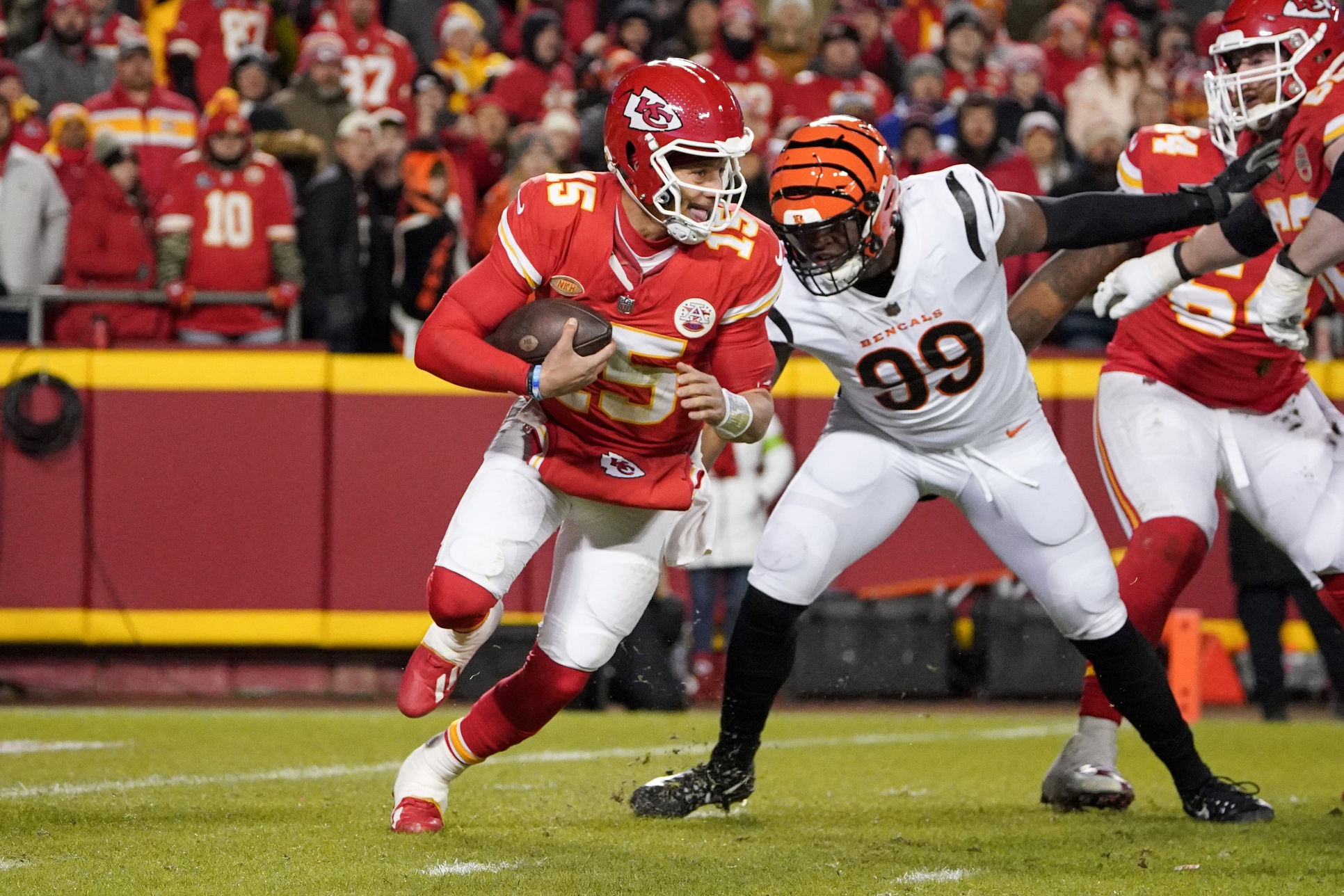 Dec 31, 2023; Kansas City, Missouri, USA; Kansas City Chiefs quarterback Patrick Mahomes (15) scrambles as Cincinnati Bengals defensive end Myles Murphy (99) pressures during the second half at GEHA Field at Arrowhead Stadium.