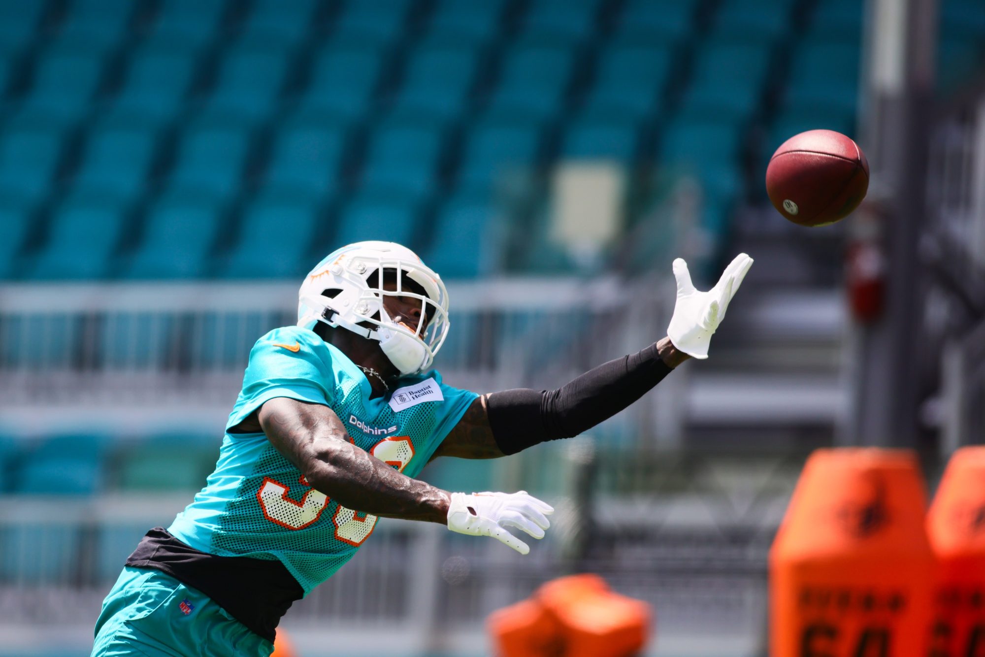 Jun 4, 2024; Miami Gardens, FL, USA; Miami Dolphins cornerback Siran Neal (33) reaches for the football during mandatory minicamp at Baptist Health Training Complex.