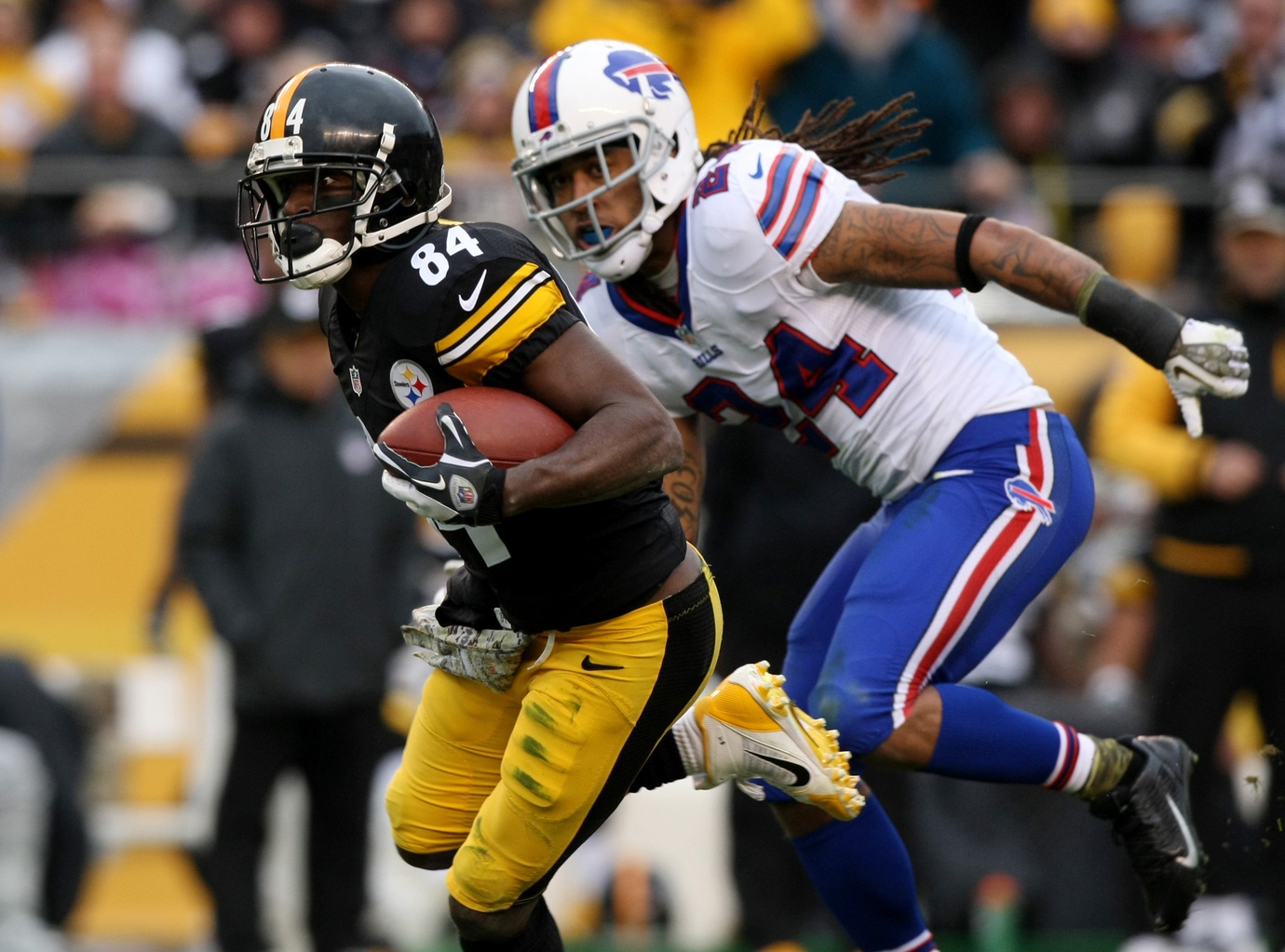 Nov 10, 2013; Pittsburgh, PA, USA; Pittsburgh Steelers wide receiver Antonio Brown (84) runs the ball past Buffalo Bills cornerback Stephen Gilmore (24) during the second half at Heinz Field. The Steelers won the game, 23-10.