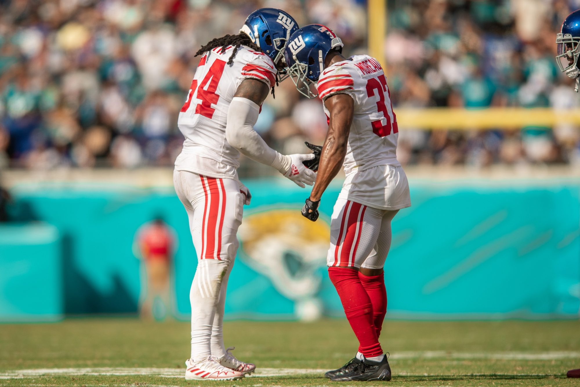 Oct 23, 2022; Jacksonville, Florida, USA; New York Giants linebacker Jaylon Smith (54) and New York Giants defensive back Fabian Moreau (37) celebrate a turnover in the fourth quarter at TIAA Bank Field.