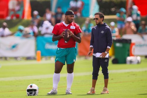 Jul 28, 2024; Miami Gardens, FL, USA; Miami Dolphins quarterback Tua Tagovailoa (1) talks to head coach Mike McDaniel during training camp at Baptist Health Training Complex.