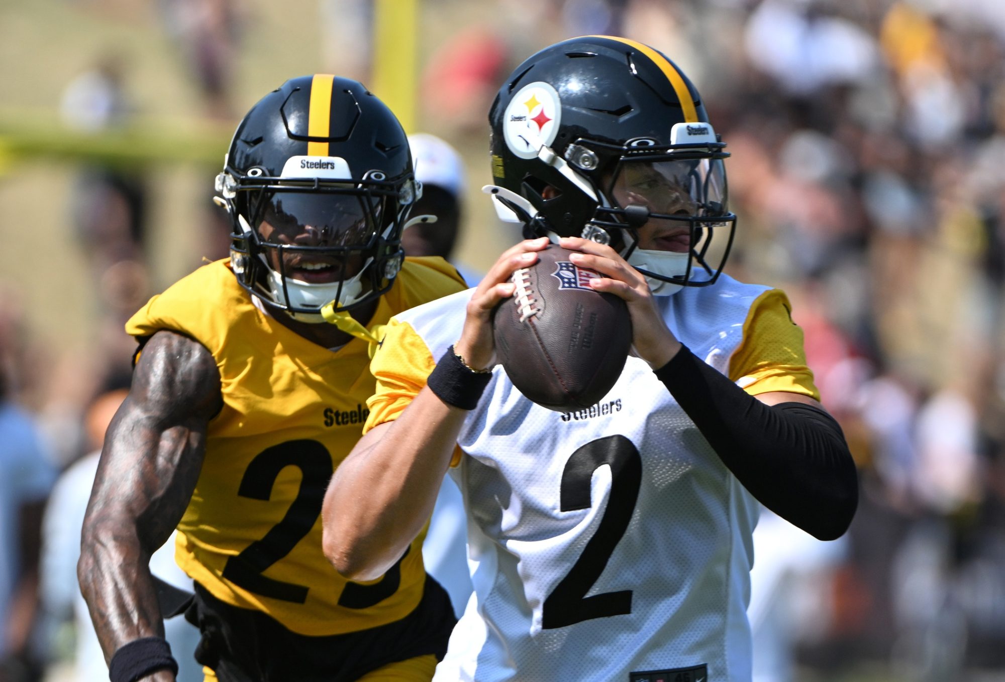 Jul 28, 2024; Latrobe, PA, USA; Pittsburgh Steelers quarterback Justin Fields (2) is pressured by safety DeShon Elliott (25) during training camp at Saint Vincent College.