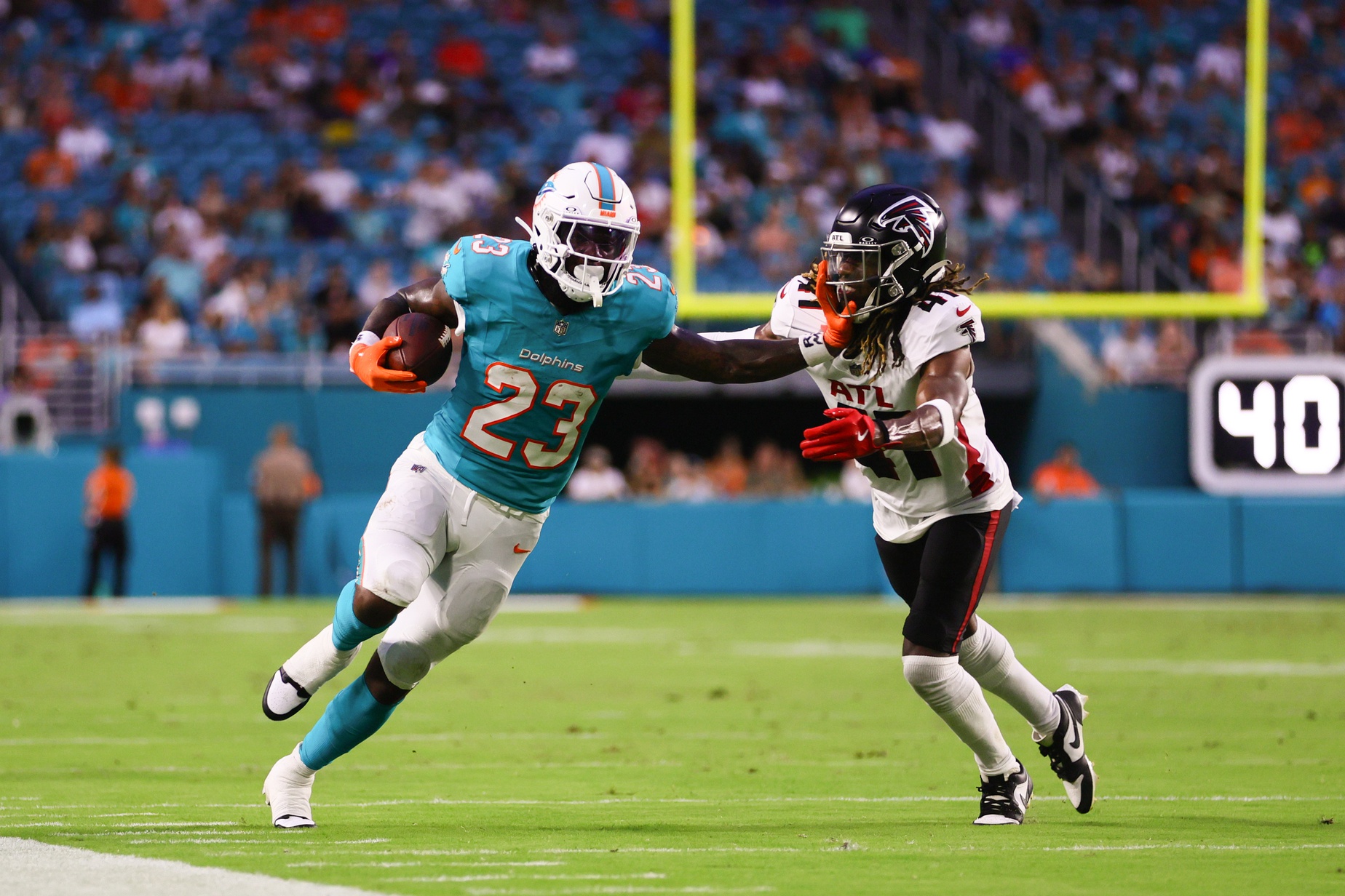 Aug 9, 2024; Miami Gardens, Florida, USA; Miami Dolphins running back Jeff Wilson Jr. (23) stiff-arms Atlanta Falcons safety Lukas Denis (41) during the first quarter at Hard Rock Stadium.