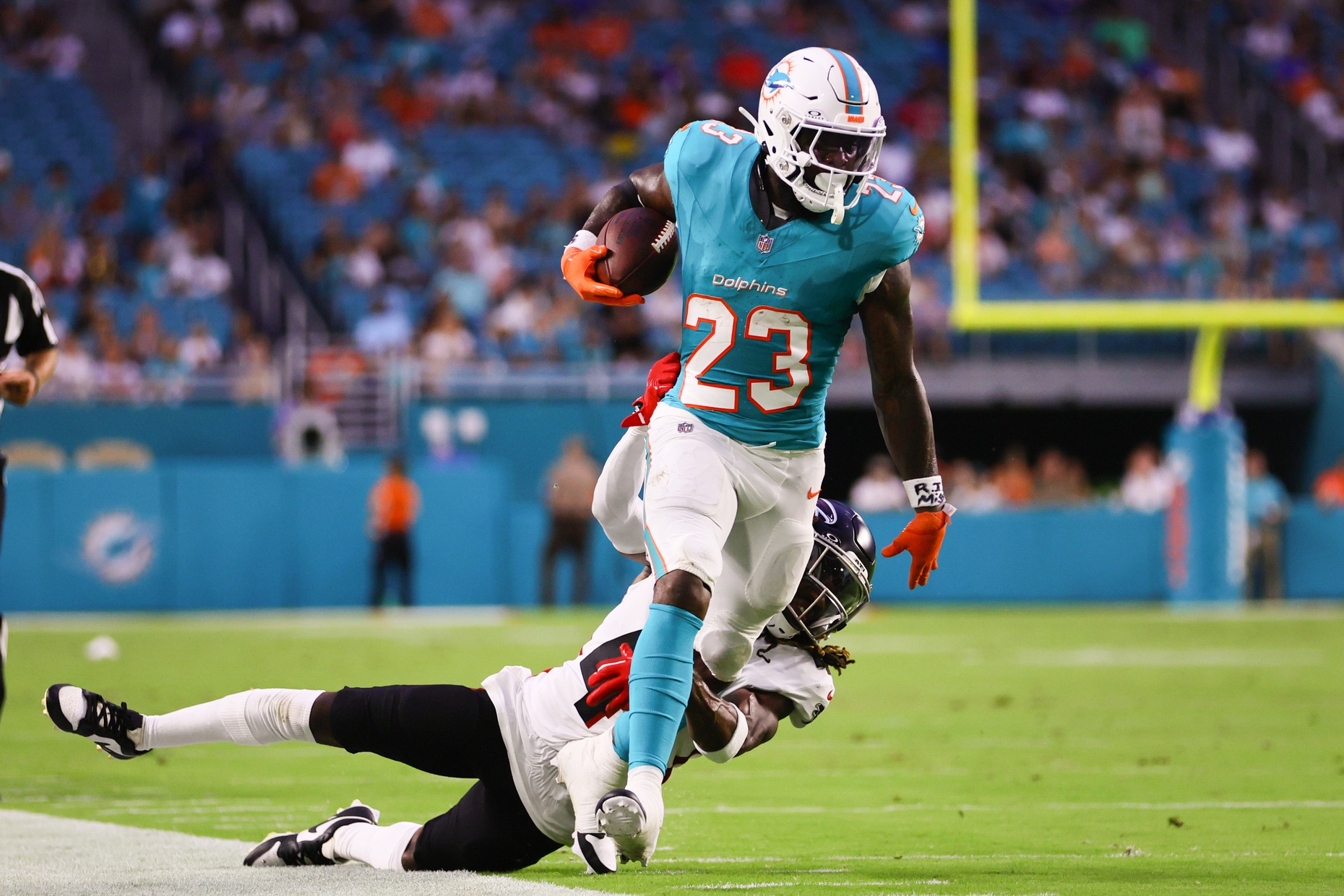 Aug 9, 2024; Miami Gardens, Florida, USA; Miami Dolphins running back Jeff Wilson Jr. (23) runs with the football past Atlanta Falcons safety Lukas Denis (41) during the first quarter at Hard Rock Stadium.