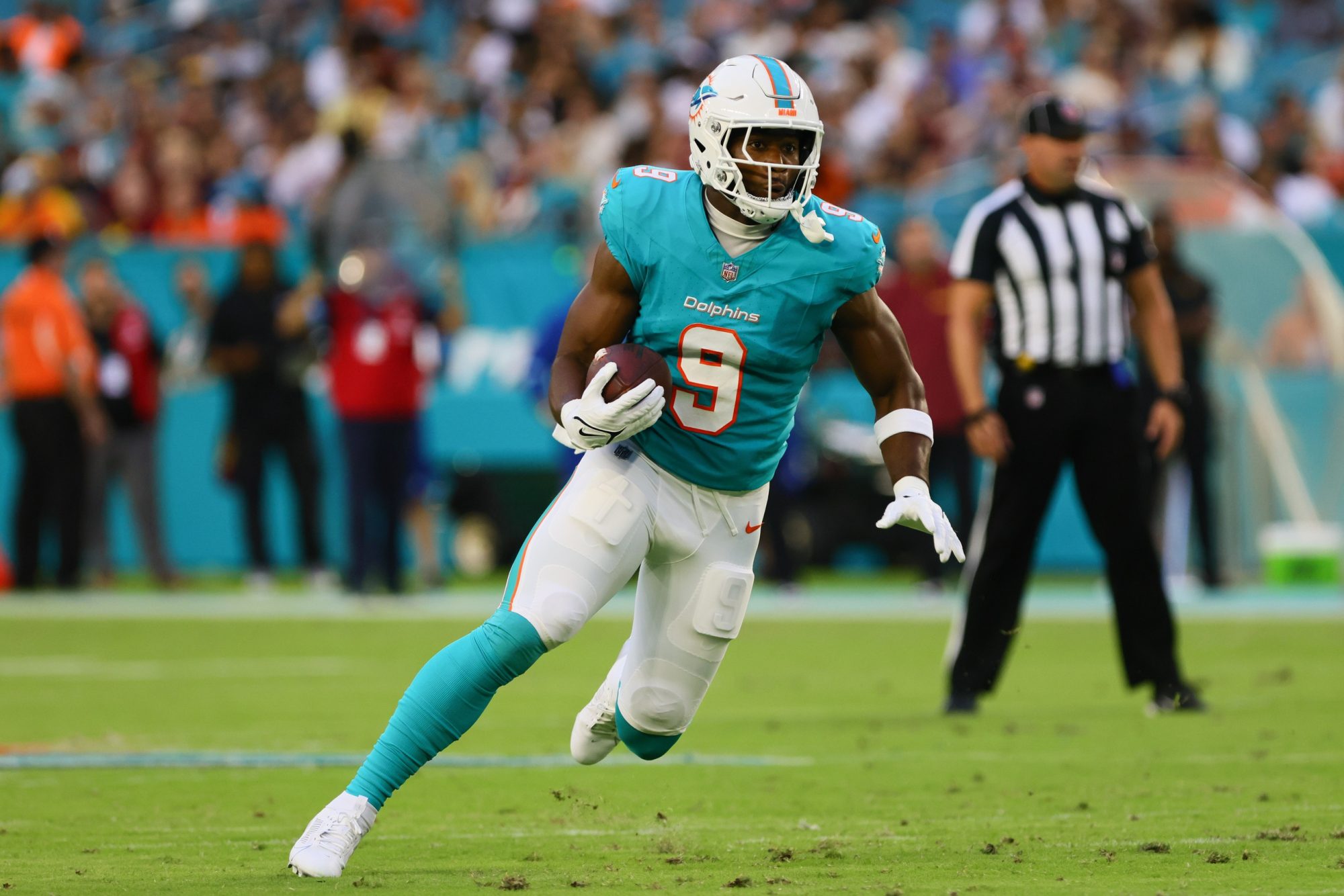 Aug 17, 2024; Miami Gardens, Florida, USA; Miami Dolphins tight end Jonnu Smith (9) runs with the football against the Washington Commanders during the first quarter of a preseason game at Hard Rock Stadium.