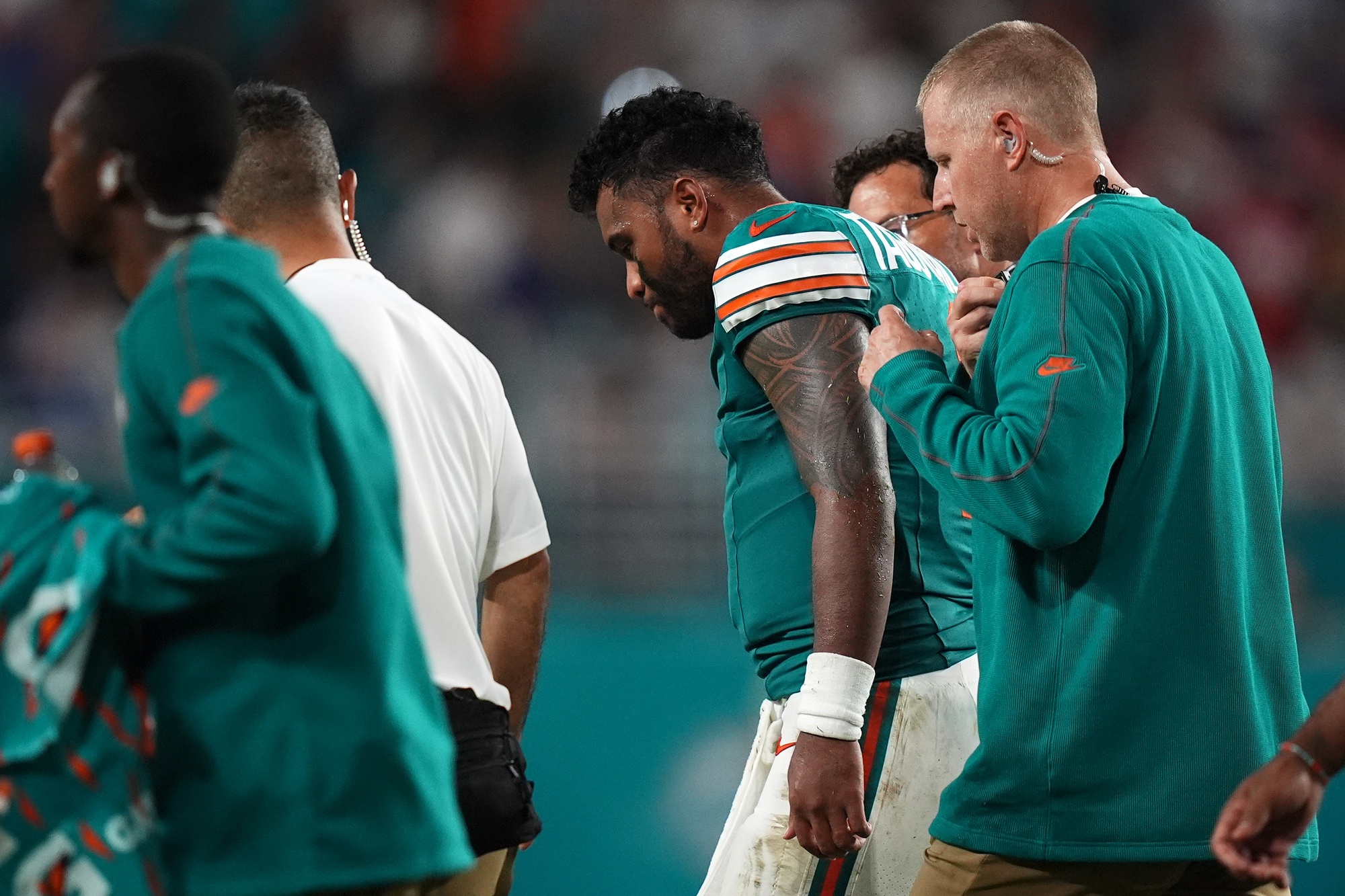 Sep 12, 2024; Miami Gardens, Florida, USA; Miami Dolphins quarterback Tua Tagovailoa (1) walks off the field with training staff after an apparent injury during the second half against the Buffalo Bills at Hard Rock Stadium.