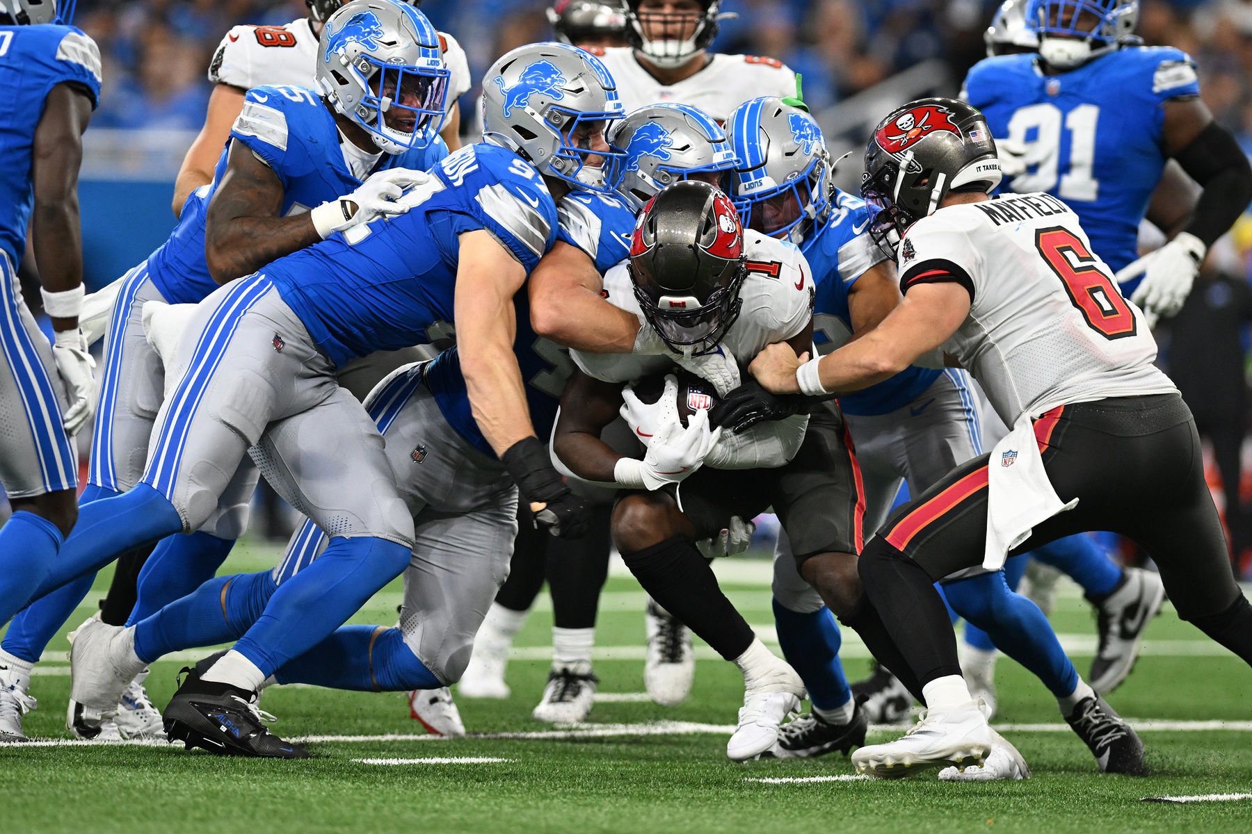 Sep 15, 2024; Detroit, Michigan, USA; Tampa Bay Buccaneers running back Rachaad White (1) gets gang tackled by Detroit Lions defensive end Aidan Hutchinson (97) linebacker Jack Campbell (46) and safety Brian Branch (32) in the third quarter at Ford Field.