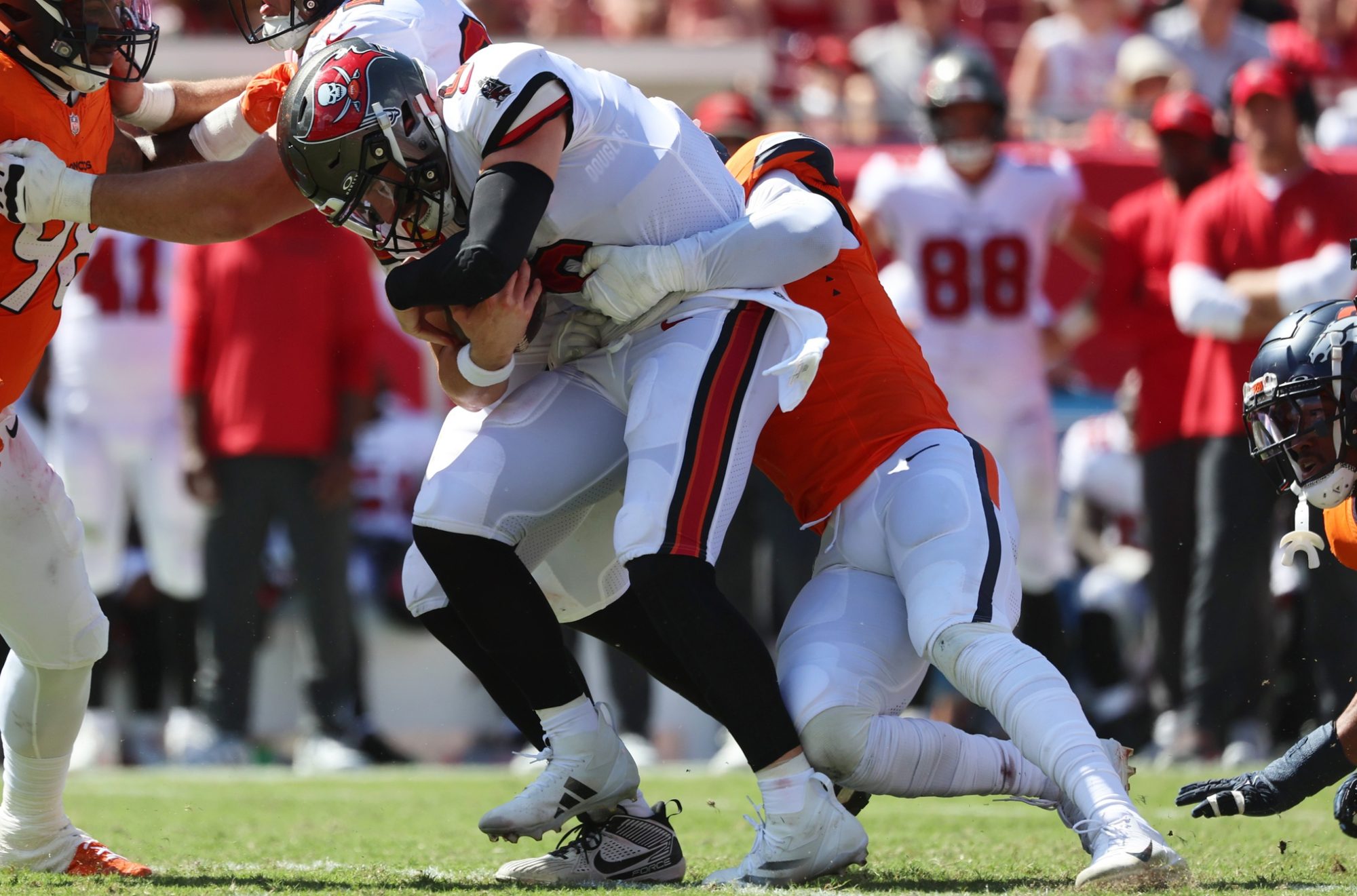 Sep 22, 2024; Tampa, Florida, USA; Denver Broncos linebacker Jonathon Cooper (0) sacks Tampa Bay Buccaneers quarterback Baker Mayfield (6) during the second half at Raymond James Stadium.