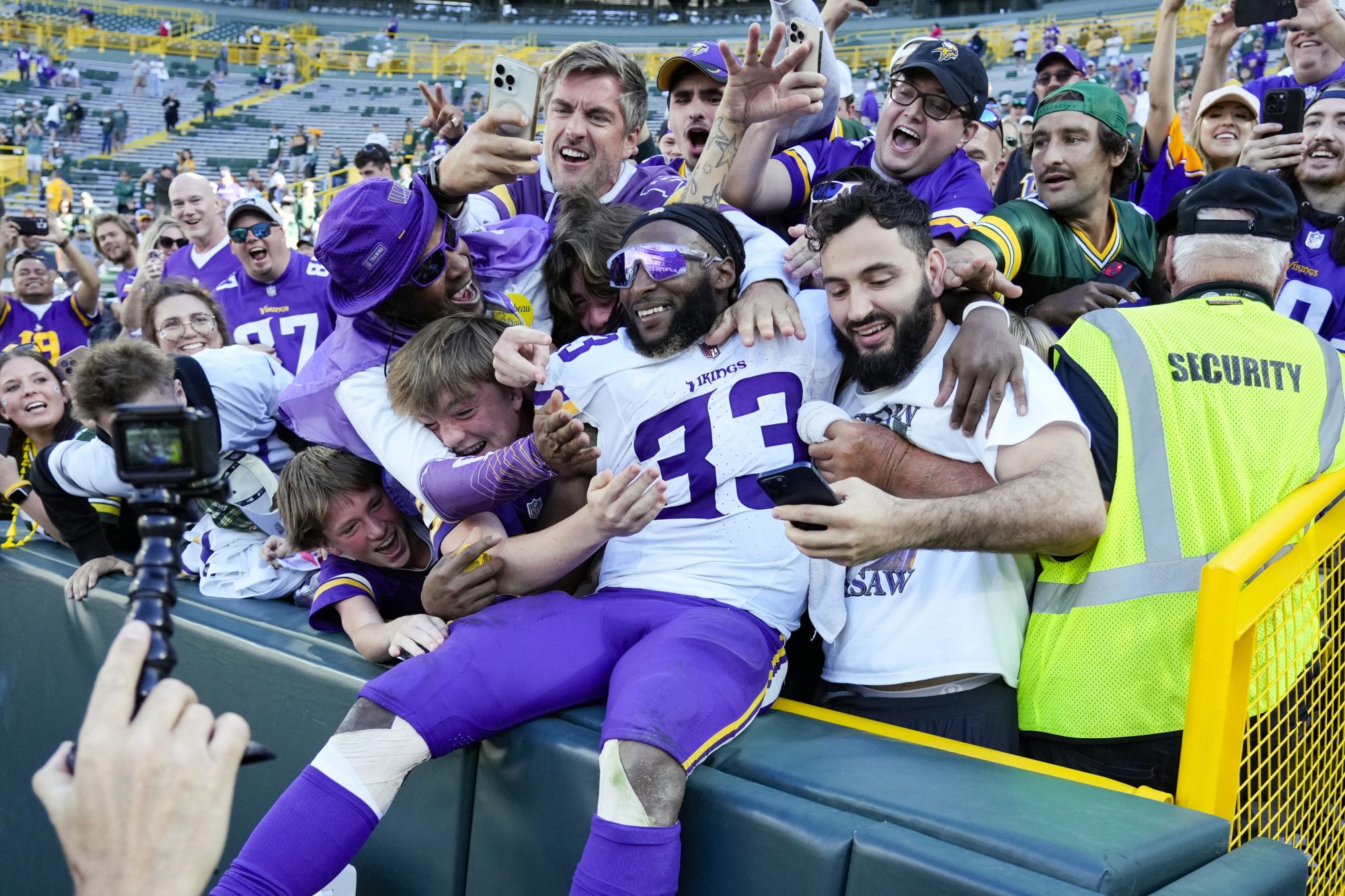 Sep 29, 2024; Green Bay, Wisconsin, USA; Minnesota Vikings running back Aaron Jones (33) celebrates by jumping in to the stands following the game against the Green Bay Packers at Lambeau Field.