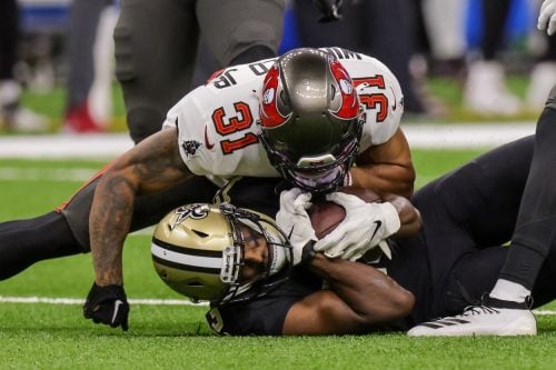 Sep 18, 2022; New Orleans, Louisiana, USA; Tampa Bay Buccaneers safety Antoine Winfield Jr. (31) tackles New Orleans Saints wide receiver Michael Thomas (13) during the first half at Caesars Superdome.