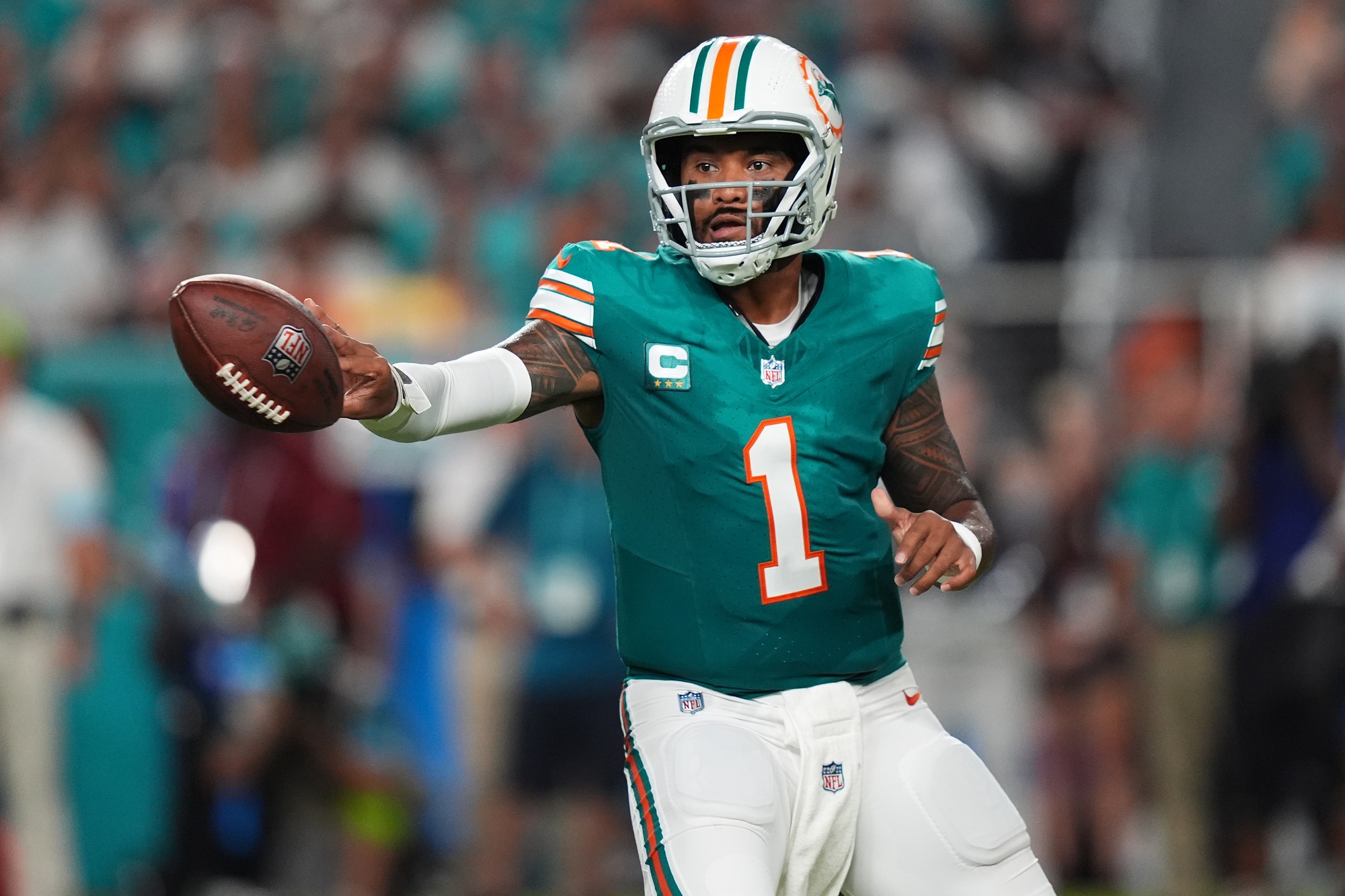 Sep 12, 2024; Miami Gardens, Florida, USA; Miami Dolphins quarterback Tua Tagovailoa (1) tosses the ball during the first half against the Buffalo Bills at Hard Rock Stadium.