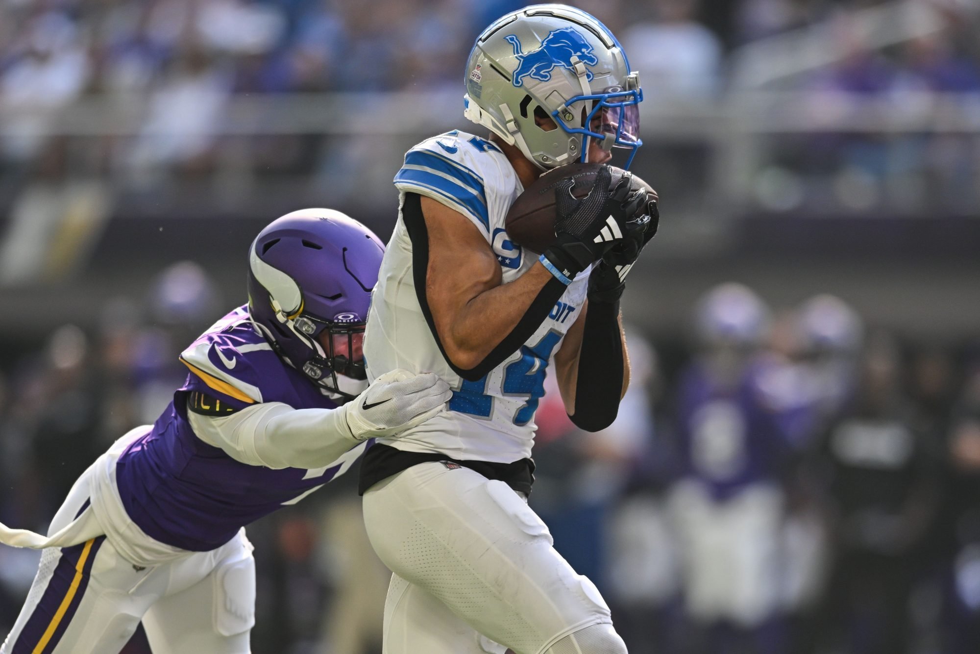 Oct 20, 2024; Minneapolis, Minnesota, USA; Detroit Lions wide receiver Amon-Ra St. Brown (14) catches a 35 yard touchdown pass from quarterback Jared Goff (not pictured) as Minnesota Vikings cornerback Byron Murphy Jr. (7) defends during the second quarter at U.S. Bank Stadium.