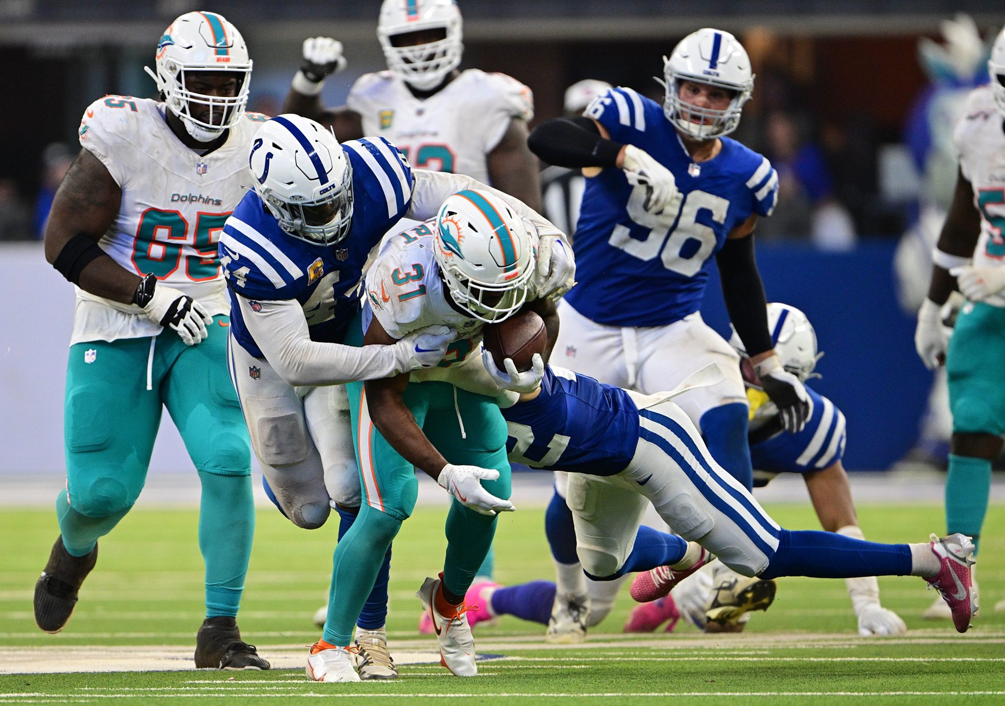 Oct 20, 2024; Indianapolis, Indiana, USA; Miami Dolphins running back Raheem Mostert (31) is tackled by Indianapolis Colts linebacker Zaire Franklin (44) during the second half at Lucas Oil Stadium.