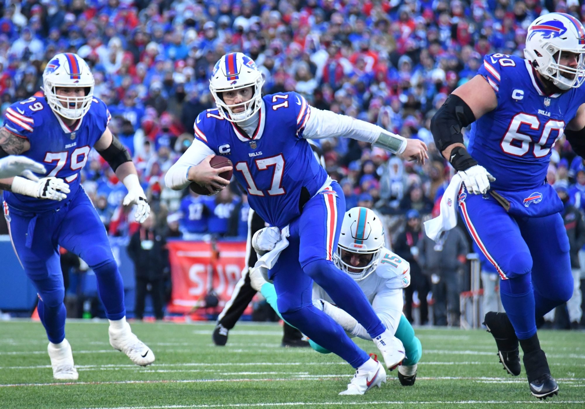 Jan 15, 2023; Orchard Park, NY, USA; Buffalo Bills quarterback Josh Allen (17) scrambles away from Miami Dolphins linebacker Jaelan Phillips (15) during the second half in a NFL wild card game at Highmark Stadium.