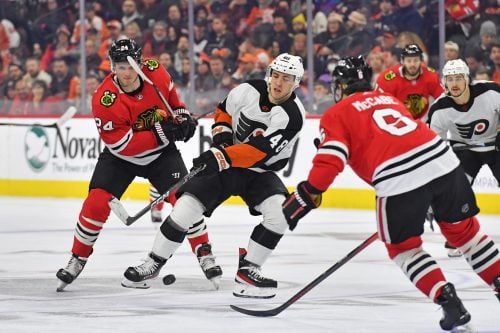 Jan 19, 2023; Philadelphia, Pennsylvania, USA; Philadelphia Flyers center Morgan Frost (48) battle for the puck with Chicago Blackhawks center Sam Lafferty (24) and defenseman Jake McCabe (6) during the third period at Wells Fargo Center.