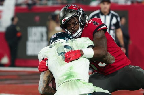 Jan 15, 2024; Tampa, Florida, USA; Tampa Bay Buccaneers cornerback Jamel Dean (35) tackles Philadelphia Eagles wide receiver DeVonta Smith (6) during the second half of a 2024 NFC wild card game at Raymond James Stadium.