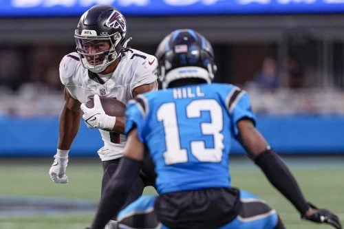 Oct 13, 2024; Charlotte, North Carolina, USA; Atlanta Falcons running back Bijan Robinson (7) tries to elude Carolina Panthers cornerback Troy Hill (13) during the second half at Bank of America Stadium.