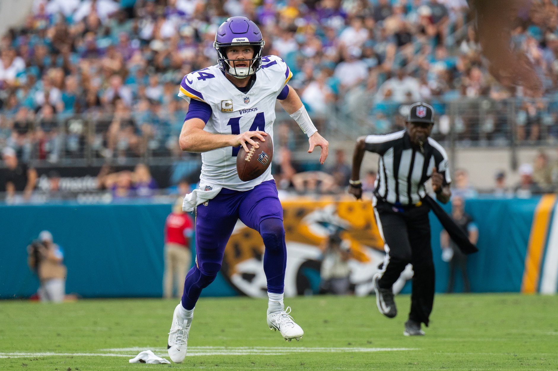 Nov 10, 2024; Jacksonville, Florida, USA; Minnesota Vikings quarterback Sam Darnold (14) runs the ball against the Jacksonville Jaguars in the second quarter at EverBank Stadium.