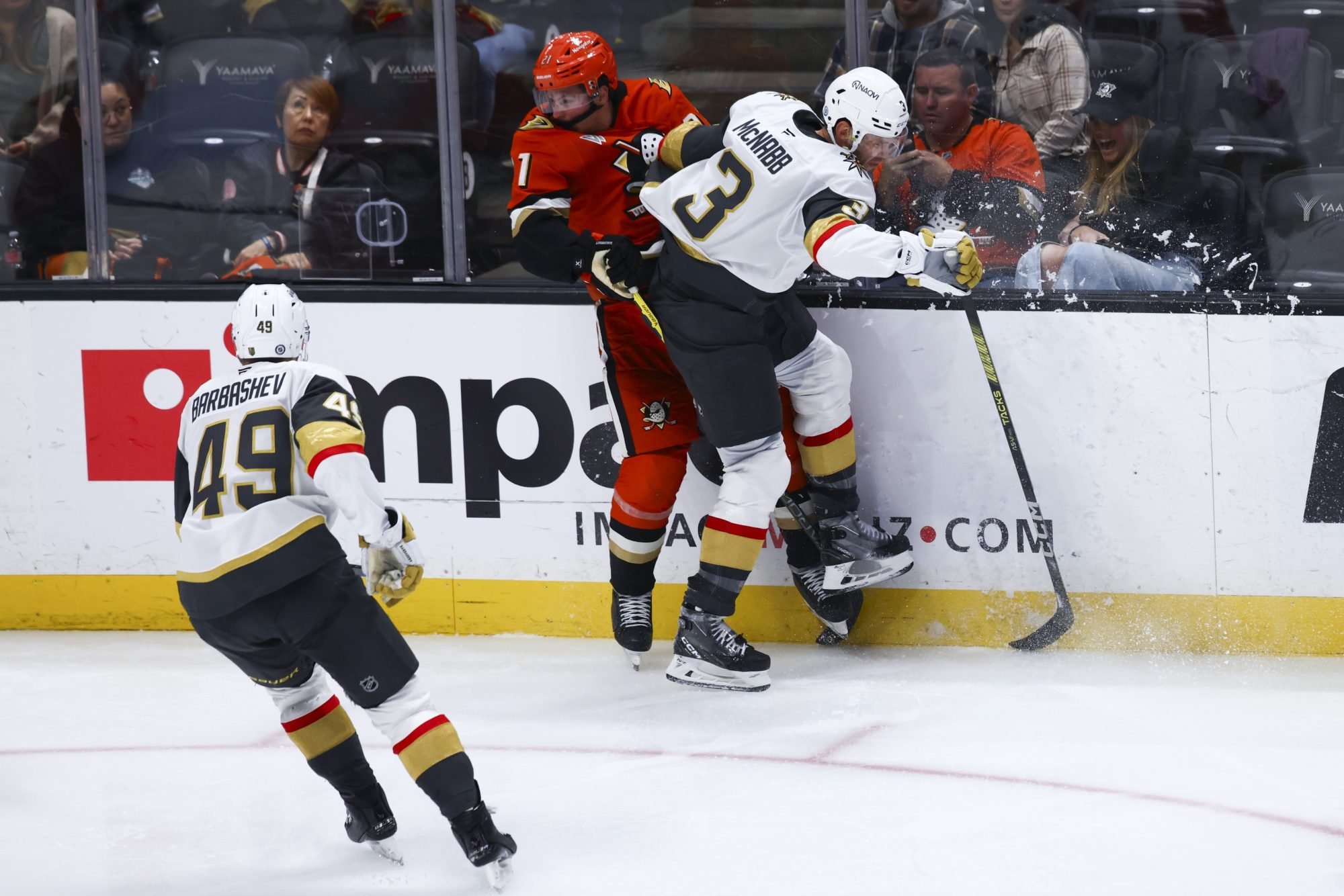 Nov 13, 2024; Anaheim, California, USA; Vegas Golden Knights defenseman Brayden McNabb (3) checks Anaheim Ducks center Isac Lundestrom (21) into the boards during the third period of a hockey game at Honda Center.