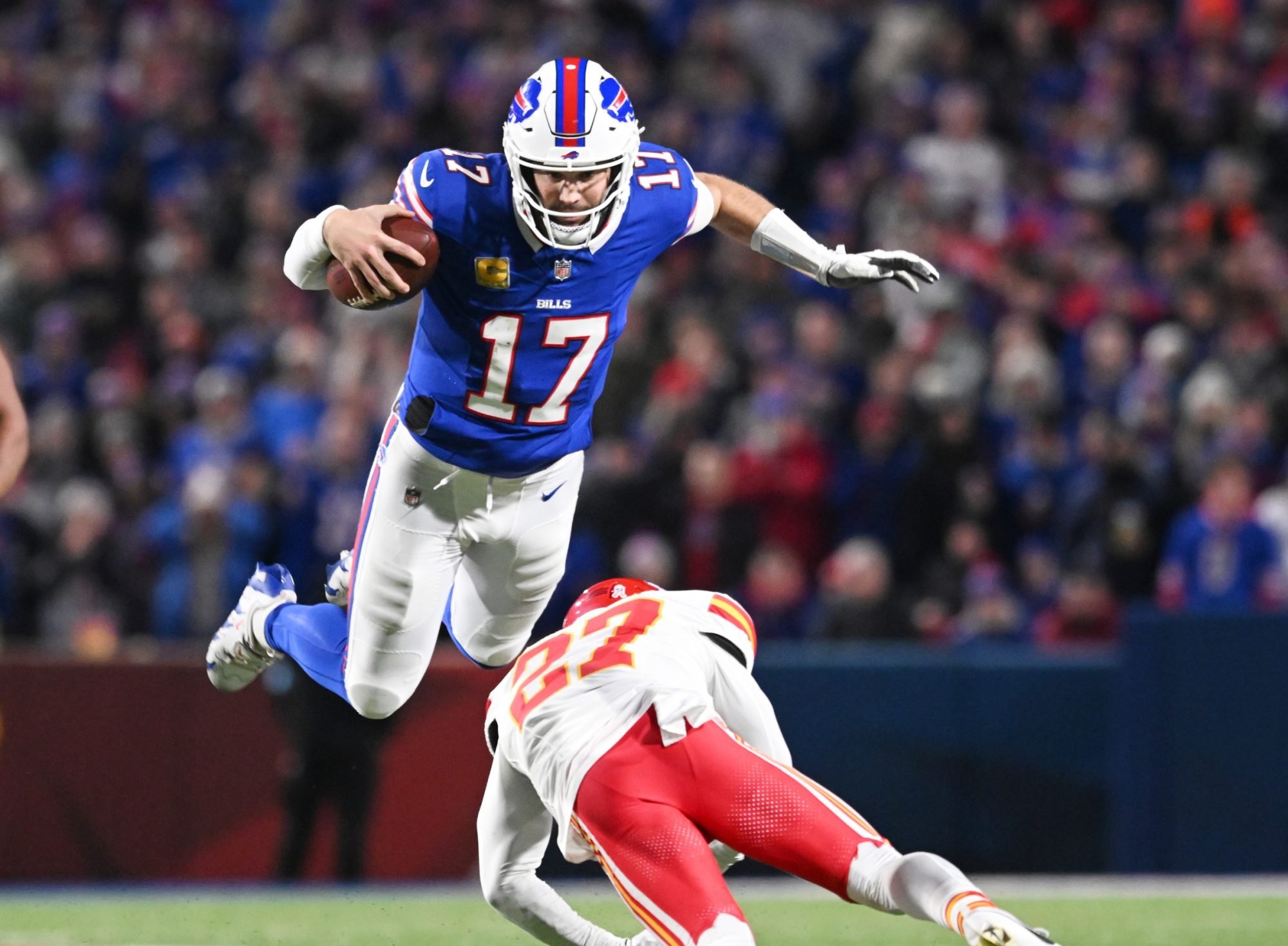 Nov 17, 2024; Orchard Park, New York, USA; Buffalo Bills quarterback Josh Allen (17) leaps over Kansas City Chiefs safety Chamarri Conner (27) to get a first down at Highmark Stadium.