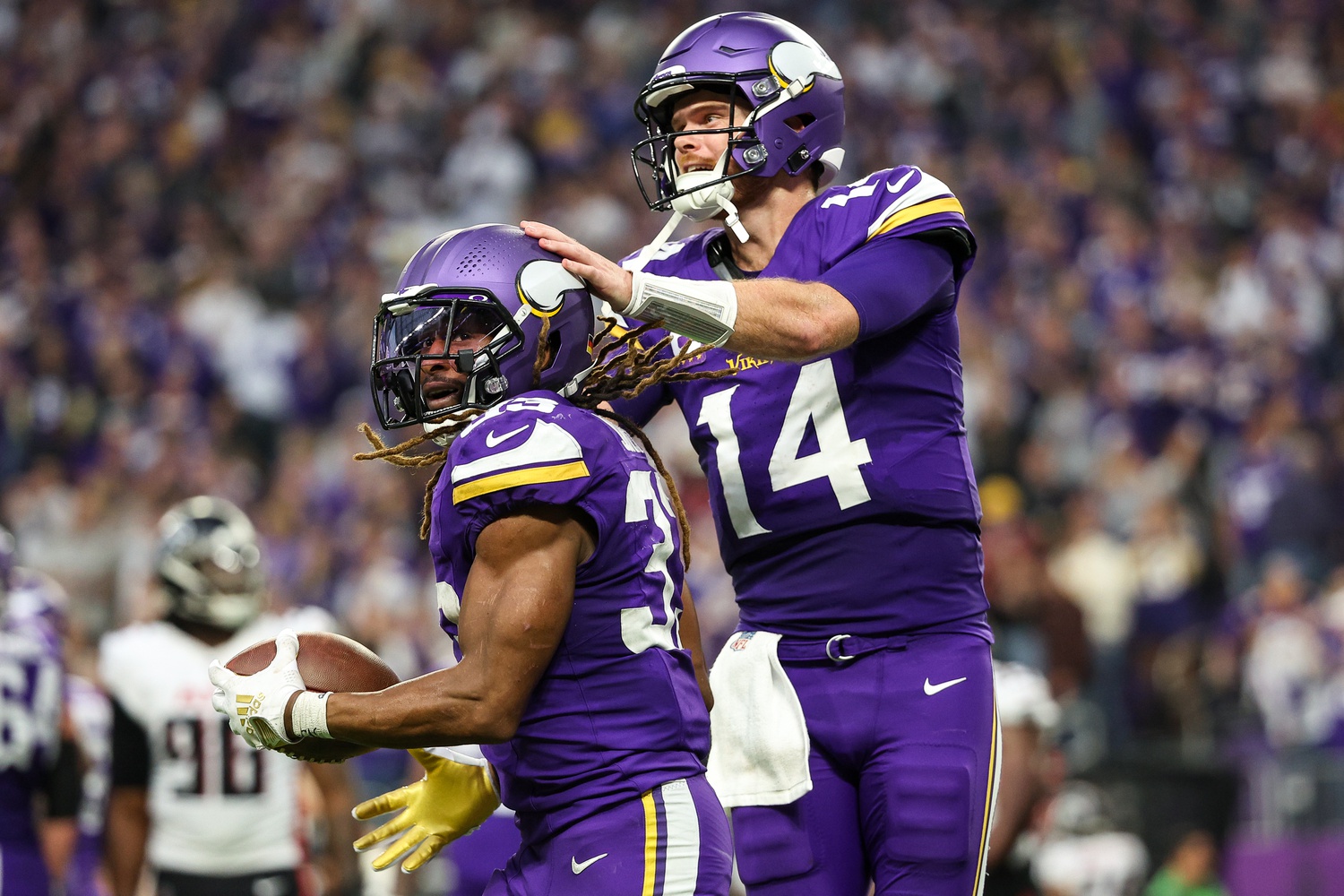 Dec 8, 2024; Minneapolis, Minnesota, USA; Minnesota Vikings running back Aaron Jones (33) celebrates his running touchdown with quarterback Sam Darnold (14) during the fourth quarter against the Atlanta Falcons at U.S. Bank Stadium.