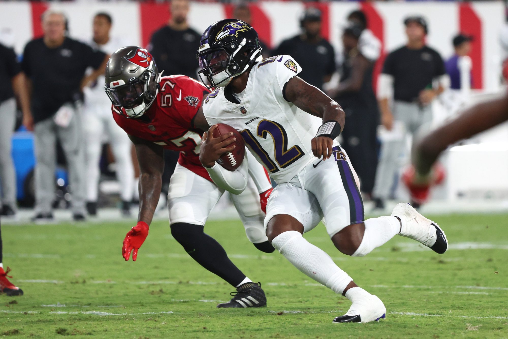 Aug 26, 2023; Tampa, Florida, USA; Baltimore Ravens quarterback Anthony Brown (12) runs with the ball as Tampa Bay Buccaneers linebacker Ulysees Gilbert (57) defends during the second quarter at Raymond James Stadium.