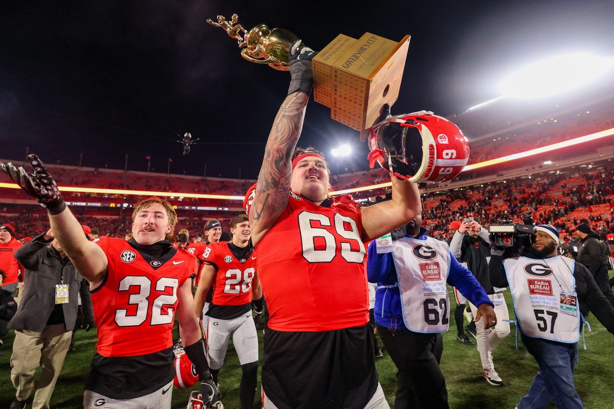 Nov 29, 2024; Athens, Georgia, USA; Georgia Bulldogs offensive lineman Tate Ratledge (69) holds the Governor’s Cup with running back Cash Jones (32) after a victory over the Georgia Tech Yellow Jackets in eight overtimes at Sanford Stadium.