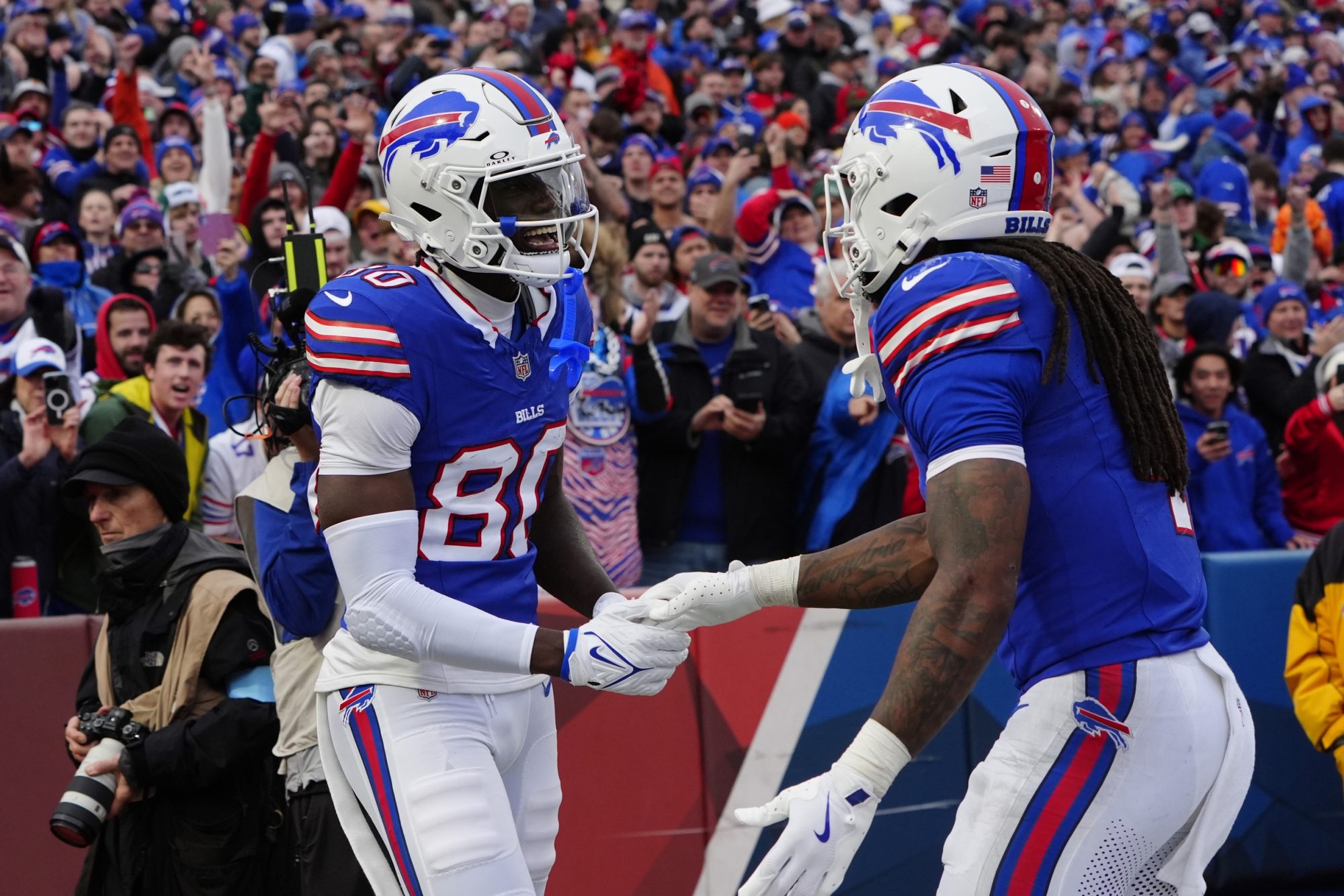 Dec 29, 2024; Orchard Park, New York, USA; Buffalo Bills running back James Cook (4) congratulates Buffalo Bills wide receiver Tyrell Shavers (80) for scoring a touchdown against the New York Jets during the second half at Highmark Stadium.