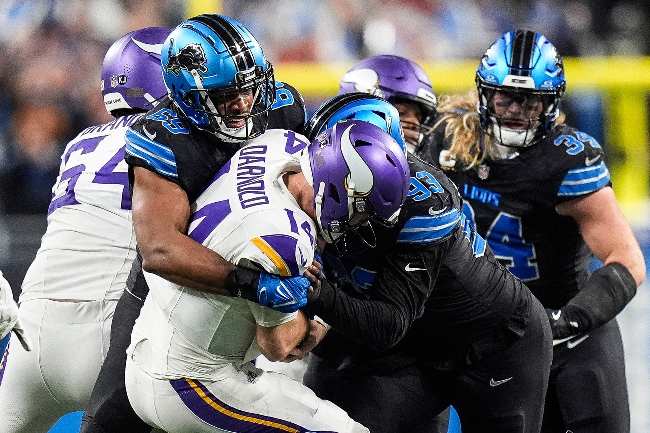 Detroit Lions linebacker Al-Quadin Muhammad (69) sacks Minnesota Vikings quarterback Sam Darnold (14) during the second half at Ford Field in Detroit on Sunday, Jan. 5, 2025.