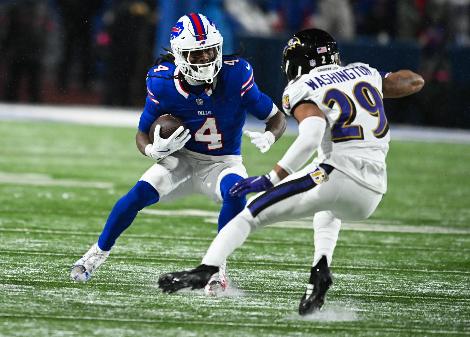 Jan 19, 2025; Orchard Park, New York, USA; Buffalo Bills running back James Cook (4) runs the ball against Baltimore Ravens safety Ar'Darius Washington (29) during the fourth quarter in a 2025 AFC divisional round game at Highmark Stadium.