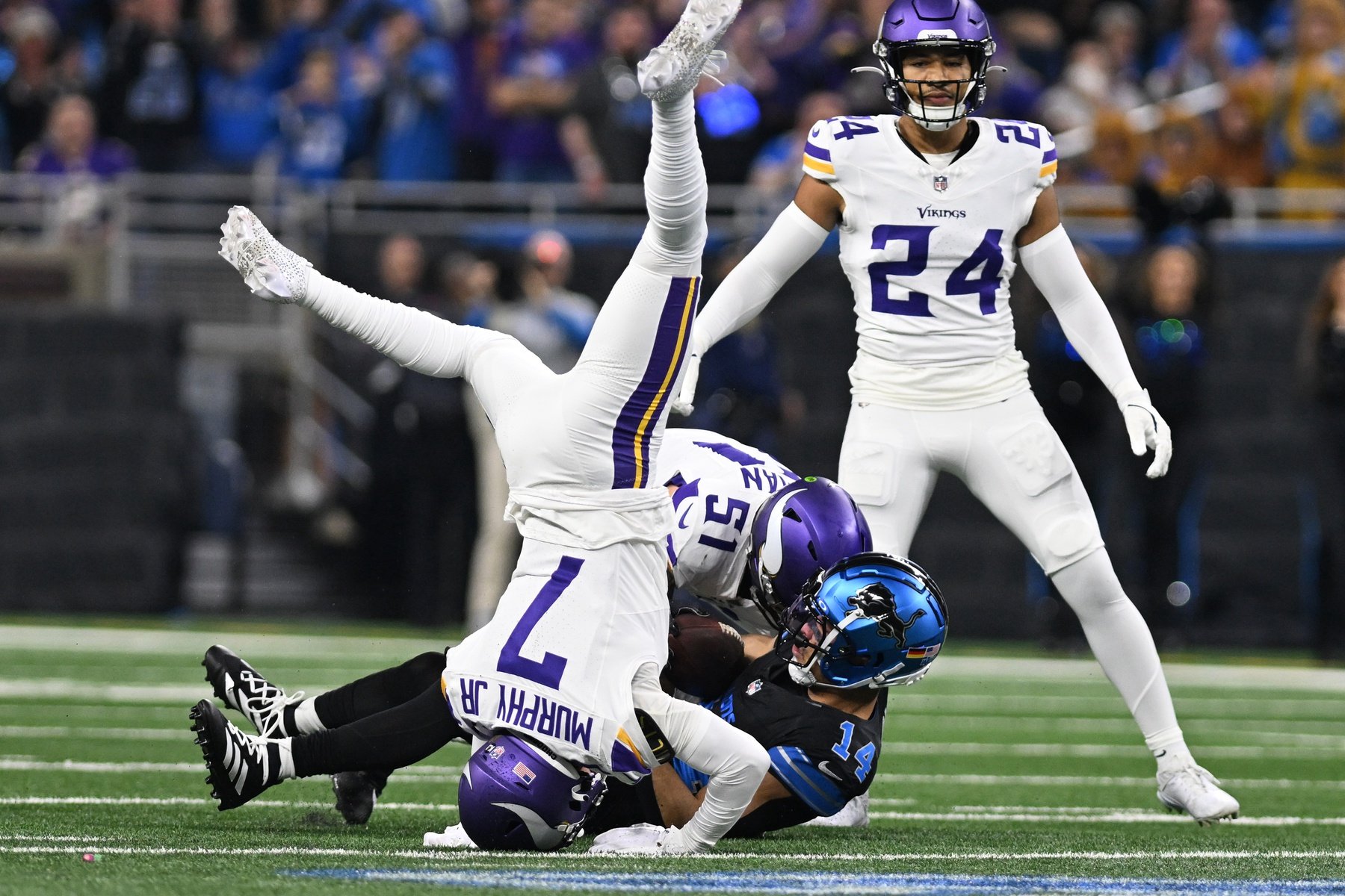 Jan 5, 2025; Detroit, Michigan, USA; Minnesota Vikings linebacker Blake Cashman (51) and cornerback Byron Murphy Jr. (7) tackle Detroit Lions wide receiver Amon-Ra St. Brown (14) after St. Brown caught a pass for a first down in the first quarter at Ford Field.